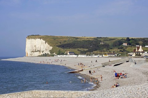 White chalk cliffs and sunbathers on pebble beach at Veulettes-sur-Mer