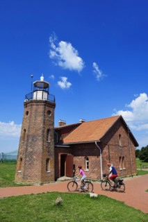 Cyclist in front of the lighthouse at the Cape of Vente