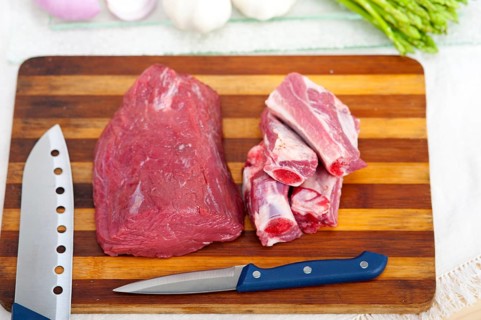 Raw beef and pork ribs with asparagus and herbs ready to cook