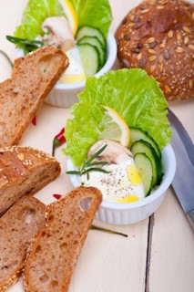 Fresh organic garlic cheese dip salad on a rustic table with bread
