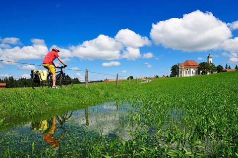 Cyclist with touring bike in front of the Wieskirche