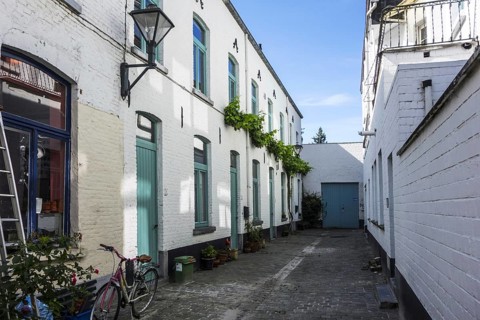 Old dead-end alley with white working-class houses in the city Aalst