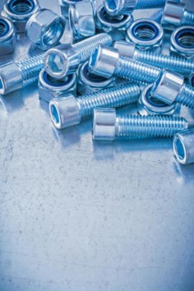 Group of threaded nuts and bolts on metallic background copy space image maintenance concept