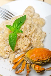 Fresh homemade Italian gnocchi with seafood sauce crab and basil