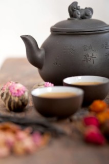Chinese style herbal floral tea over wood table with raw ingredients