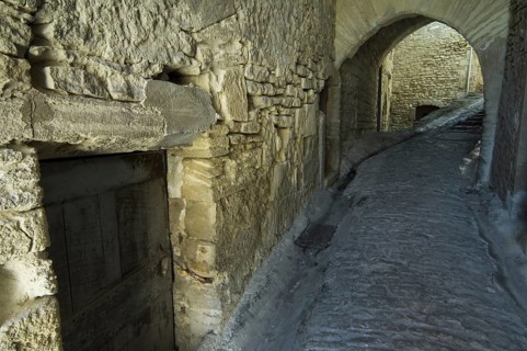 Old wooden door in alley of the medieval village Gordes
