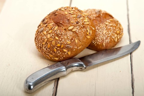 Fresh organic bread over rustic table macro closeup