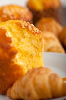 Fresh baked muffin and croissant mignon on old wood table