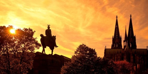 Equestrian statue of Kaiser Wilhelm II backlit with the silhouette of the cathedral