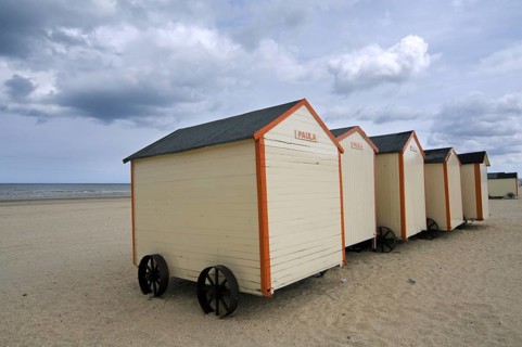 Row of colourful beach cabins on wheels along the North Sea coast at De Panne