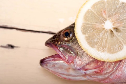 Fresh whole raw fish on a wooden table ready to cook