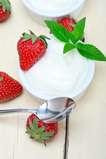 Organic Greek yogurt and strawberry over white rustic wood table