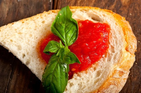 Italian fresh tomato and basil bruschetta with pecorino cheese over old wood