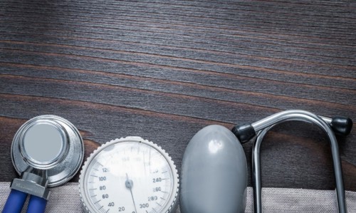 Copy room image of stethoscope and blood pressure monitor on vintage wooden medicine board concept