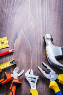 Organised copy room with construction tools ruler pencil tapping pliers pliers spanner claw hammer omvintage wooden board