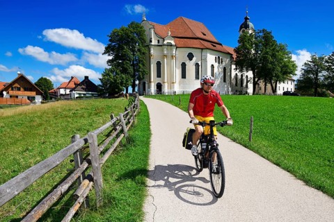 Cyclist with touring bike in front of the Wieskirche