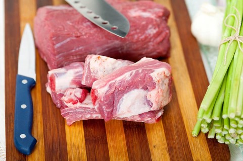 Raw beef and pork ribs with asparagus and herbs ready to cook