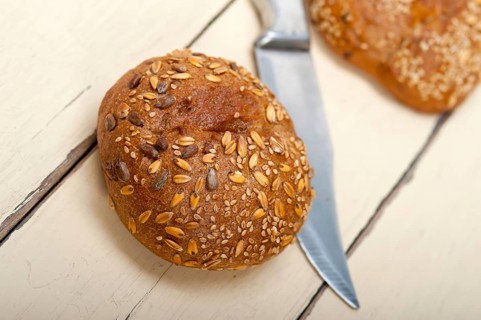 Fresh organic bread over rustic table macro closeup