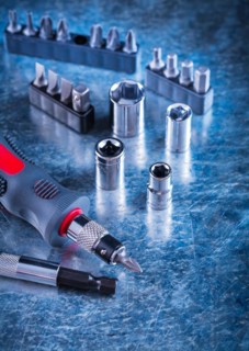 Tool set for insulated screwdrivers with interchangeable heads and bits on a design concept with a scratched metal surface