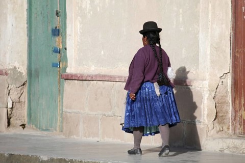 Woman in traditional dress wearing bowler hat and skirt at Uyuni