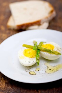 Boiled fresh green asparagus and eggs with extra virgin olive oil with rustic bread