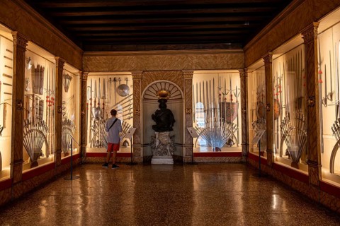Young man in an exhibition room with medieval weapons