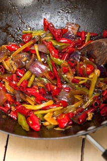 Fried chili pepper and vegetable on a iron wok pan