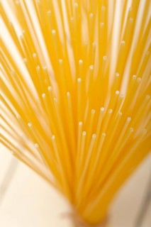 Italian pasta spaghetti tied with a rope on a rustic table