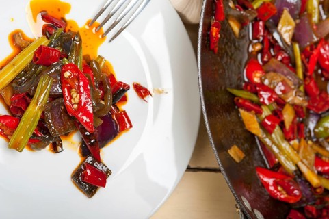 Fried chili pepper and vegetable on a iron wok pan