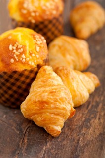 Fresh baked muffin and croissant mignon on old wood table