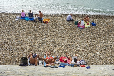 Sunbathers sunning on shingle beach along the North Sea coast