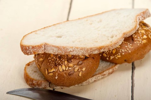 Fresh organic bread over rustic table macro closeup
