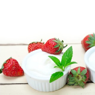 Organic Greek yogurt and strawberry over white rustic wood table