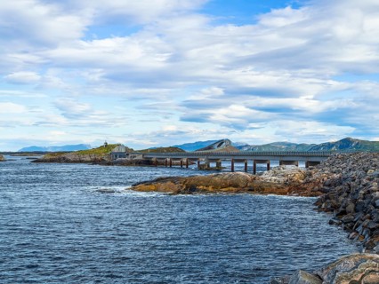 Bridge connecting rocky shores under a cloudy sky