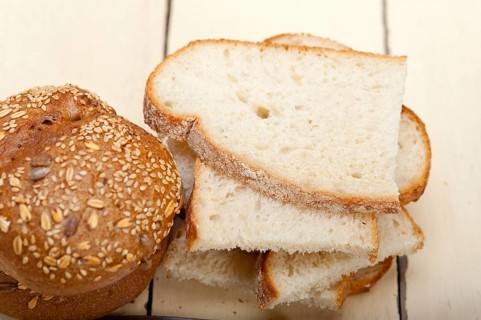Fresh organic bread over rustic table macro closeup