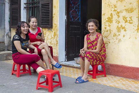 Vietnamese women sitting and chatting in front of their house in the city Ninh Binh in the Red River Delta of northern Vietnam