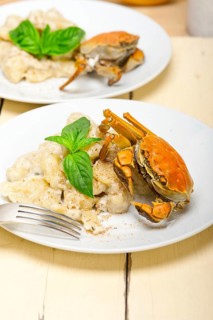 Fresh homemade Italian gnocchi with seafood sauce crab and basil