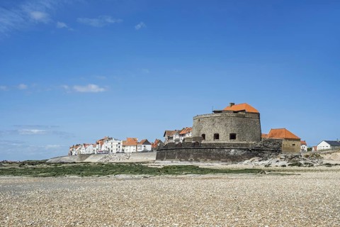 Fort Mahon and shingle beach at low tide at Ambleteuse along rocky North Sea coast