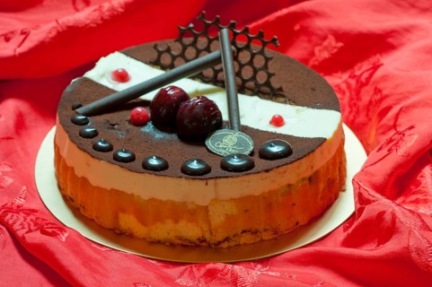 Chocolate birthday cake over red fabric background