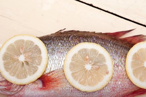 Fresh whole raw fish on a wooden table ready to cook
