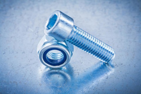 Threaded nut and bolt on metallic background Design concept