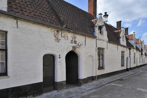 Almshouses along cobbled alley in Bruges