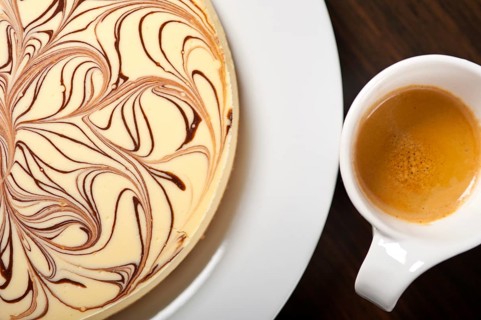 Fresh baked classic Cheese cake with chocolate topping and coffee