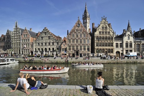 Tourists on quay along the river Lys with view over the Graslei