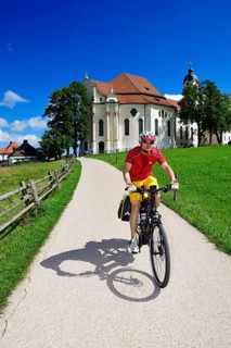 Cyclist with touring bike in front of the Wieskirche