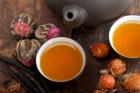 Chinese style herbal floral tea over wood table with raw ingredients