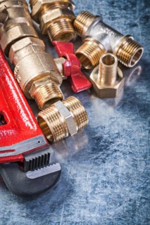 Composition of plumbing hardware on scratched metallic background construction concept