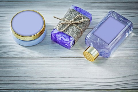 Composition of lavender handmade soap shower gel and body lotion on wooden board spa concept