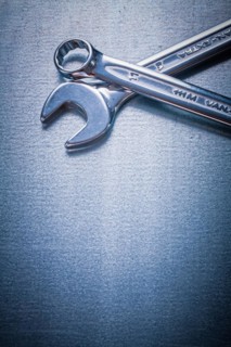 Stainless steel flat spanner and hook spanner on a metallic background Design concept