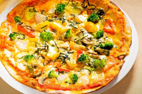 Fresh italian thin style vegetarian pizza with fresh mixed vegetables close up